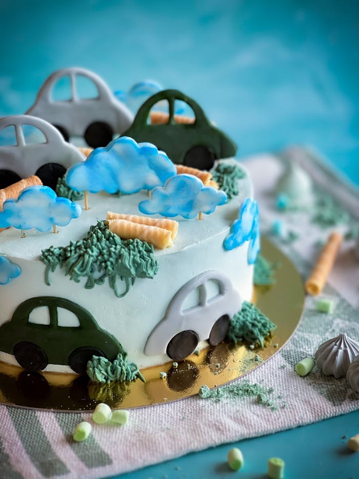 who-we-are Colorful car-themed cake with fondant decorations, perfect for a child's birthday celebration.