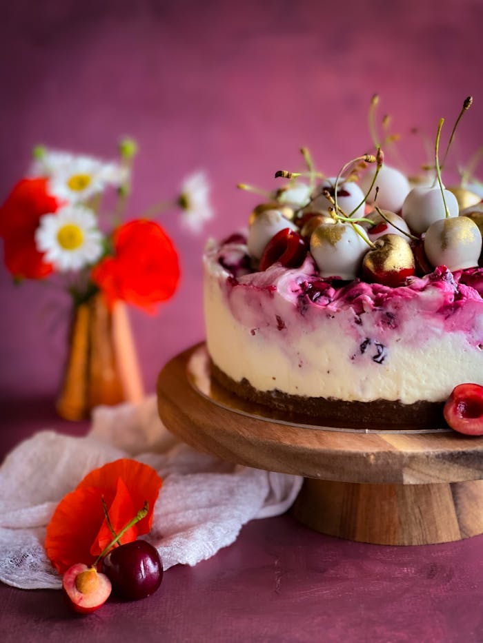 journey Delicious cherry cheesecake topped with gold cherries and flowers, perfect for celebrations.