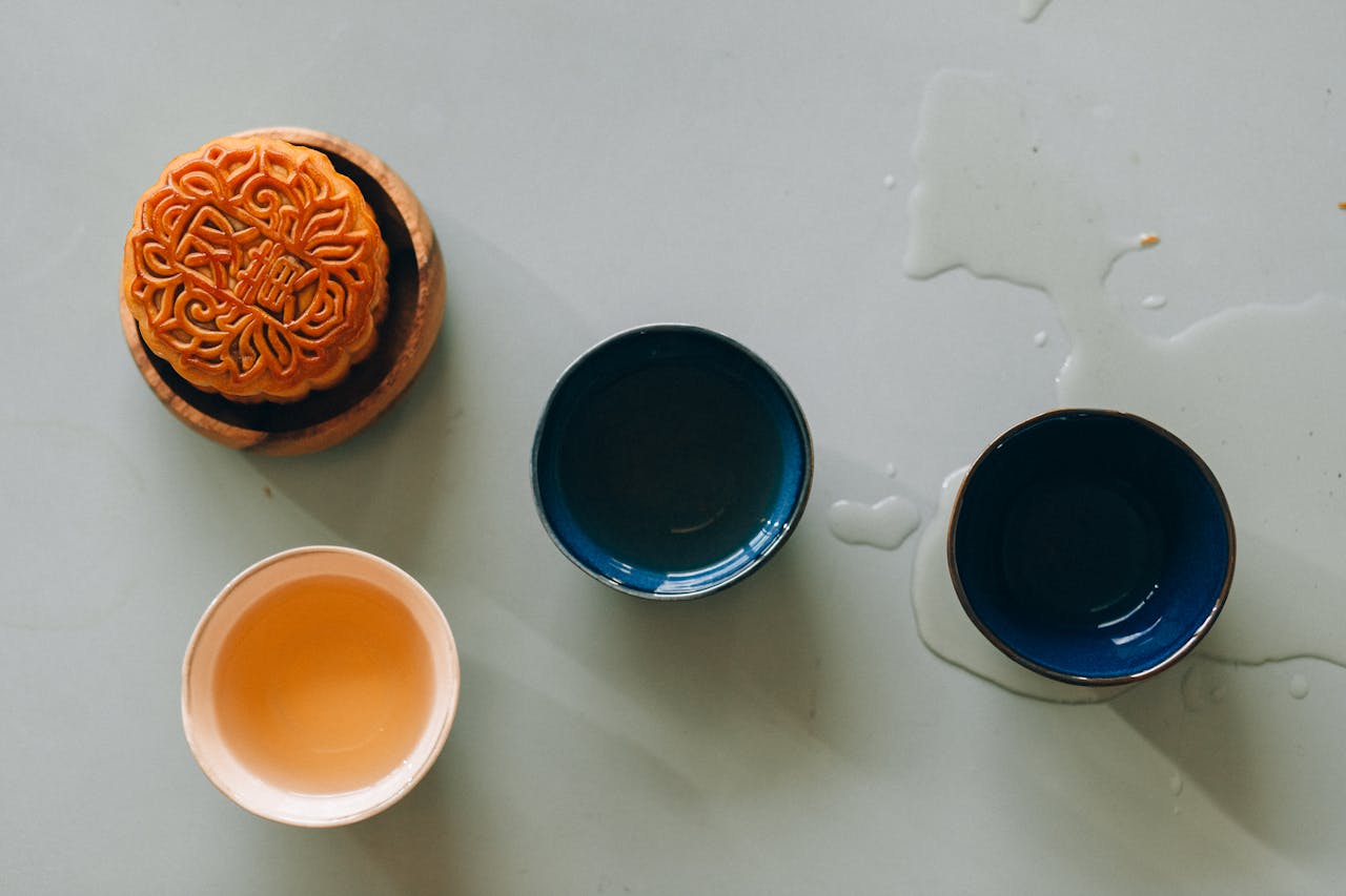 services-03 A still life image featuring a traditional mooncake and tea cups, celebrating the Mid-Autumn Festival.